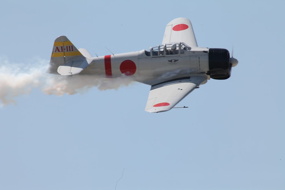 white and red jet plane in mid air during daytime