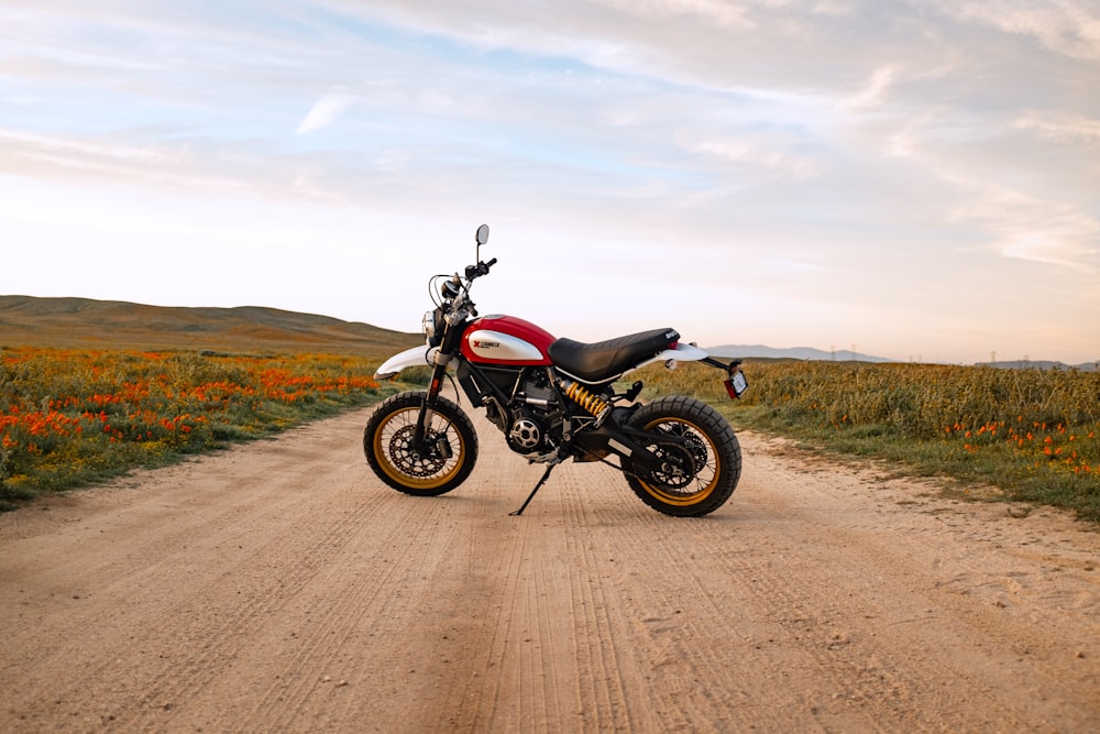 black and gray motorcycle on brown dirt road under white clouds during daytime