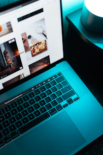 Sleek dark-themed laptop displaying a simple website layout with neon yellow highlights.