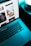 A sleek laptop on a dark desk with a glowing screen displaying a website design.