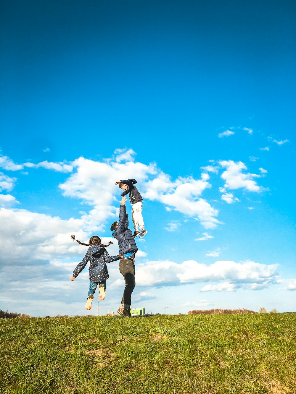 woman in white shirt and black skirt standing on green grass field under blue sky and