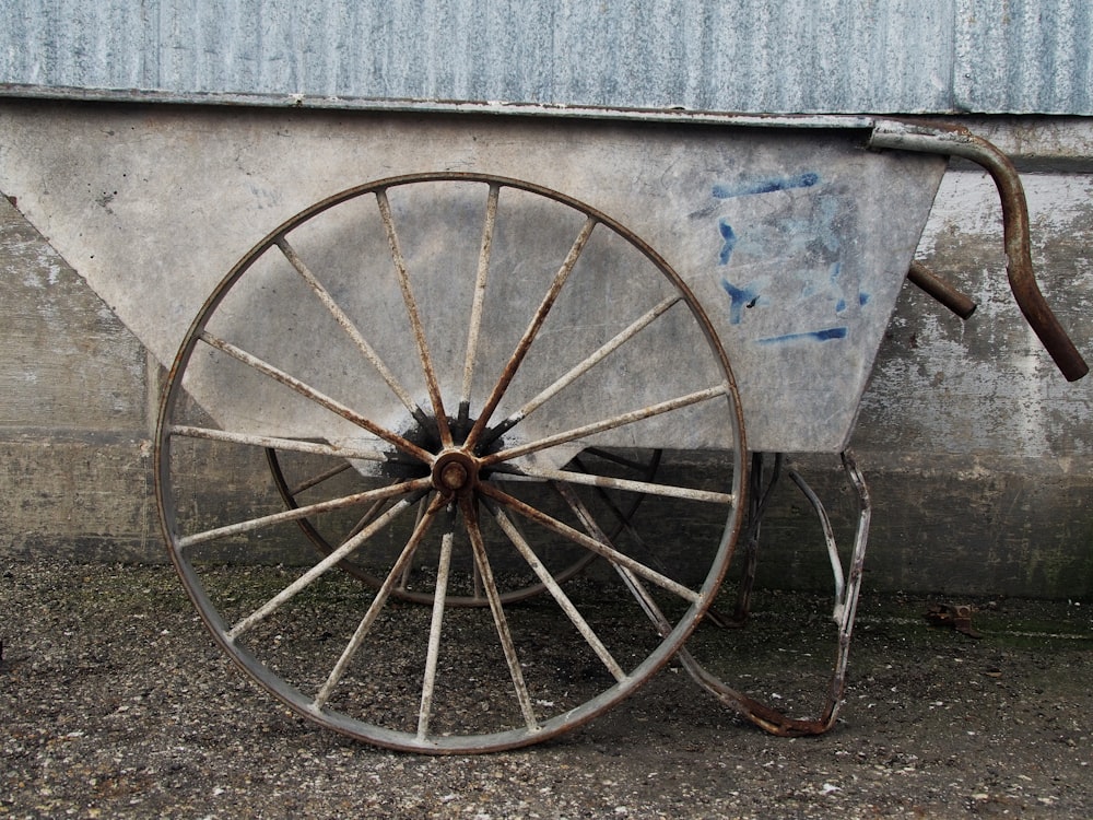 blue and brown bicycle leaning on gray wall