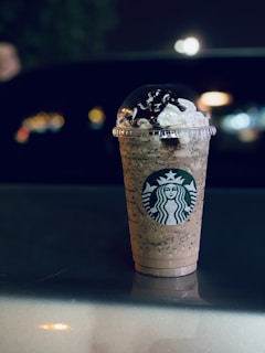 Close-up of a freshly made star frappe topped with whipped cream and vibrant toppings.