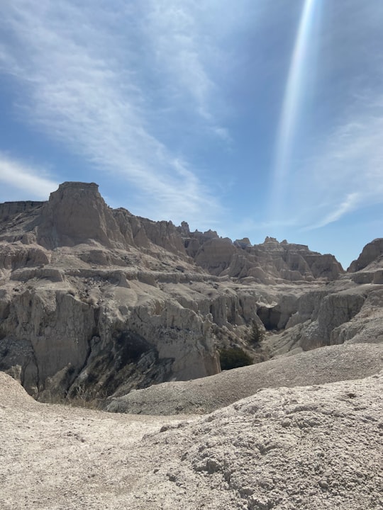 brown rocky mountain under blue sky during daytime in Badlands National Park United States