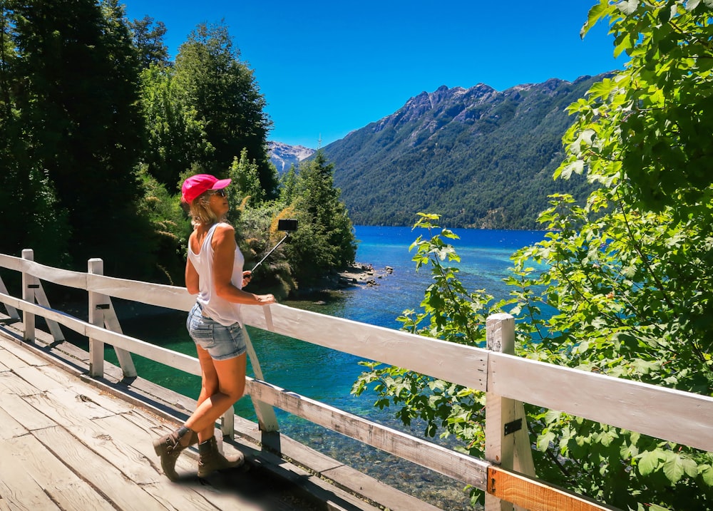 woman in white bikini standing on wooden bridge during daytime