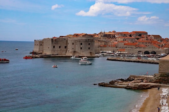 brown concrete building near body of water during daytime in Banje Beach Croatia