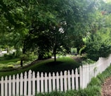 A newly installed fence enclosing a lush garden space with trimmed grass.