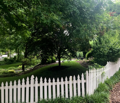 A well-constructed fence surrounding a landscaped garden.