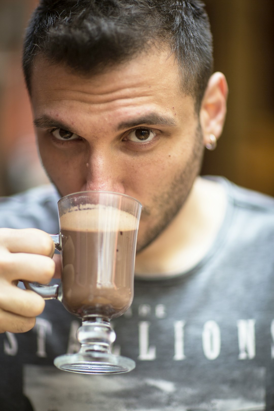 man in gray crew neck shirt holding clear glass mug