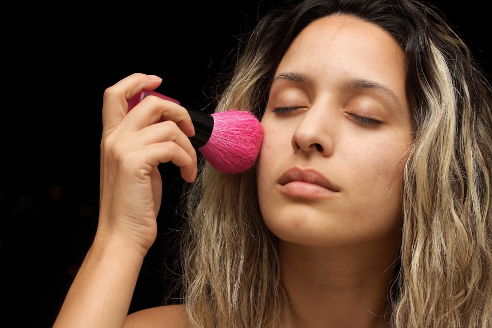 mujer con lápiz labial rosa sosteniendo su cabello