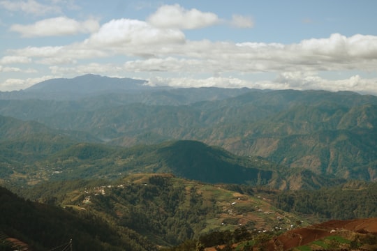 green and brown mountains under white clouds during daytime in Benguet Philippines