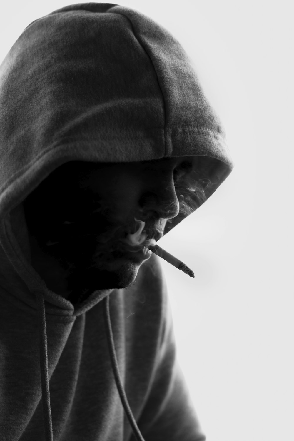 man in gray hoodie smoking cigarette