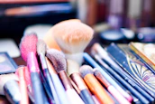 Close-up of vibrant makeup brushes and colorful cosmetics laid out invitingly.