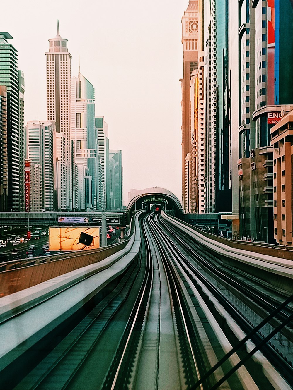 cars on road between high rise buildings during daytime