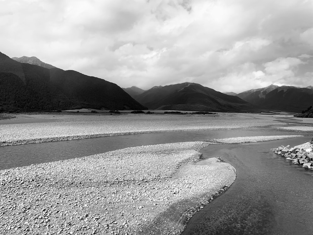 grayscale photo of mountain near body of water