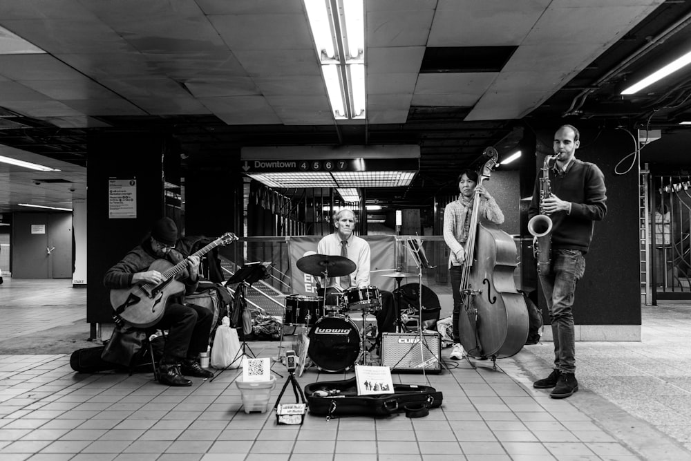 grayscale photo of band playing on stage