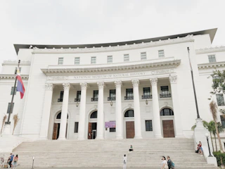 people walking in front of white concrete building during daytime