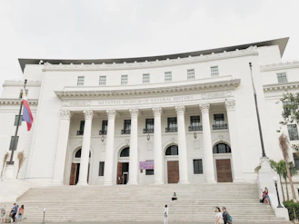 people walking in front of white concrete building during daytime
