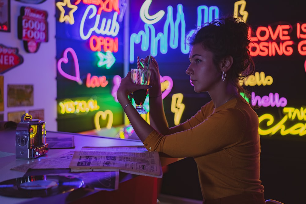 woman in brown long sleeve shirt holding a light bulb