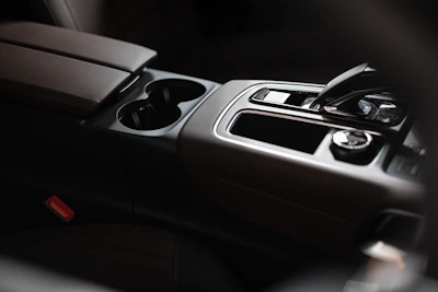 A minimalist black car console organizer fitted perfectly between the seats with compartments for gadgets and keys.