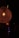A warmly lit, intricately woven lamp hangs in the dark, radiating a soft orange glow. The texture of the lamp's material adds a rustic charm to the overall aesthetic. In the background, other smaller lights are visible, faintly illuminating the surrounding area.