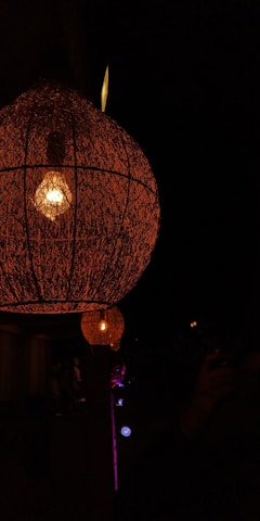 A warm-lit workspace featuring artisans crafting unique lamp designs by hand.