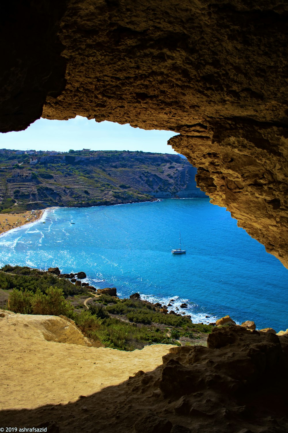 brown rock formation near body of water during daytime