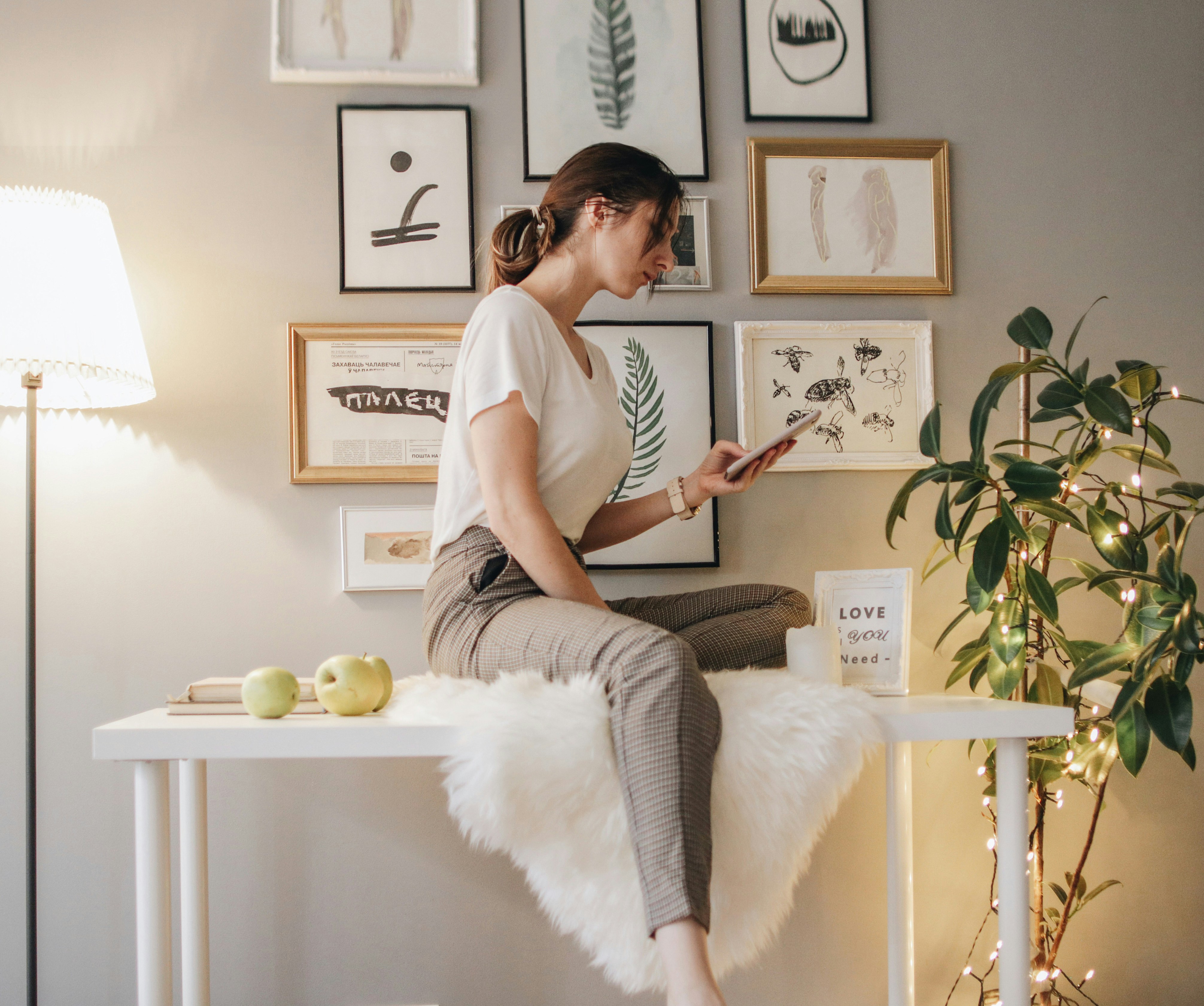 Mann in weißem Rundhals-T-Shirt und grauer Hose sitzt auf weißem Bett