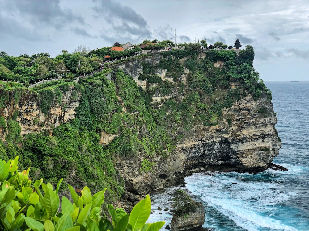 montanha verde e marrom ao lado do corpo de água durante o dia