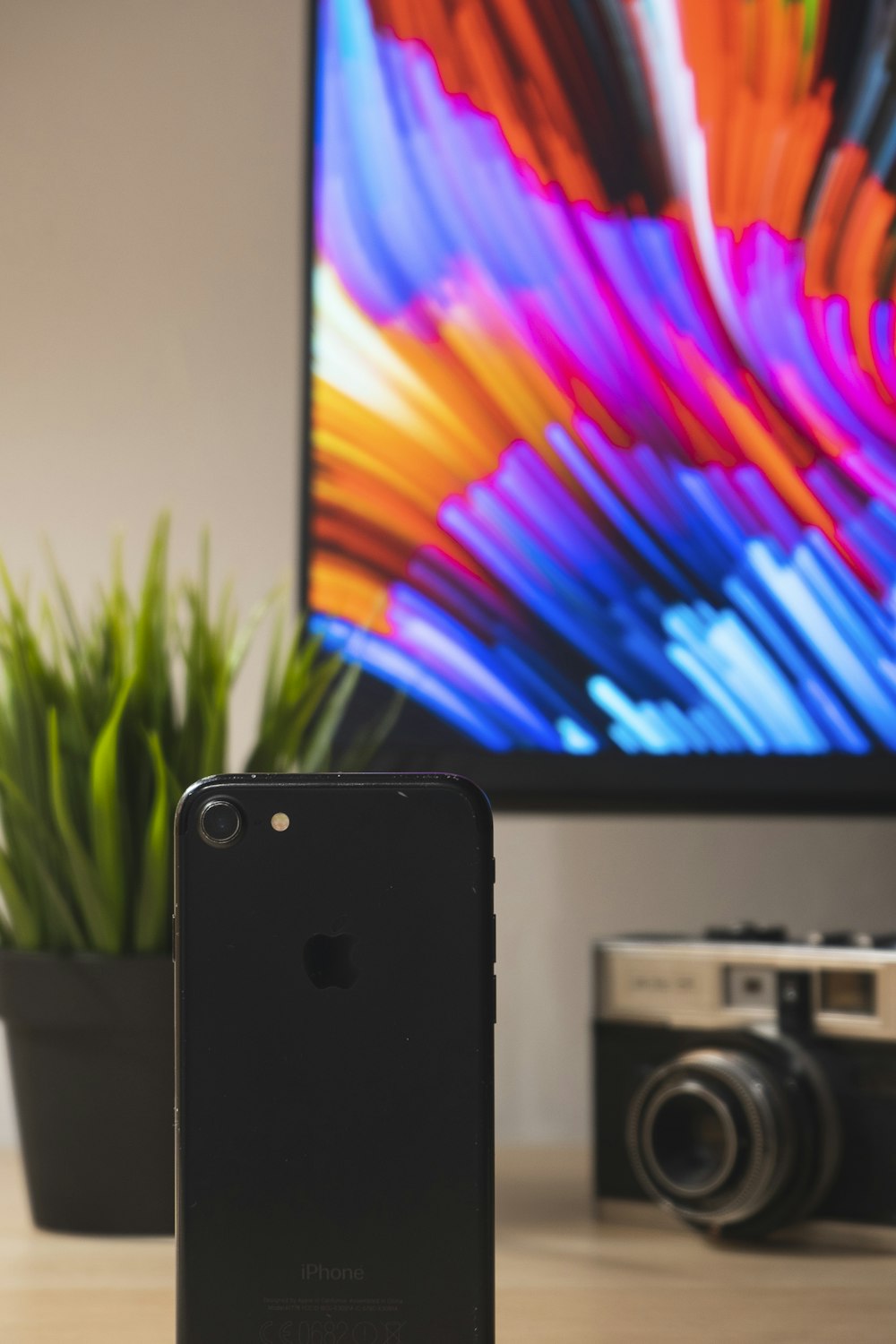 black iphone 4 beside black and silver camera