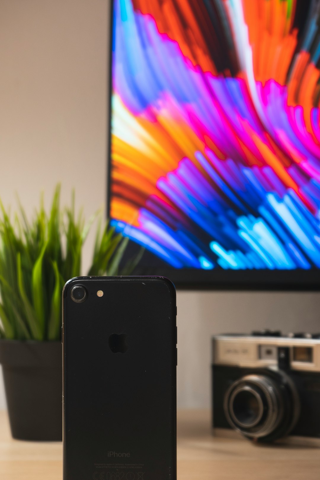 black iphone 4 beside black and silver camera