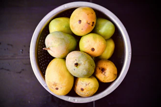 Close-up of mangoes undergoing hot water treatment in a stainless steel tank at the facility.