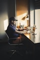 man in blue shirt sitting on chair in front of table