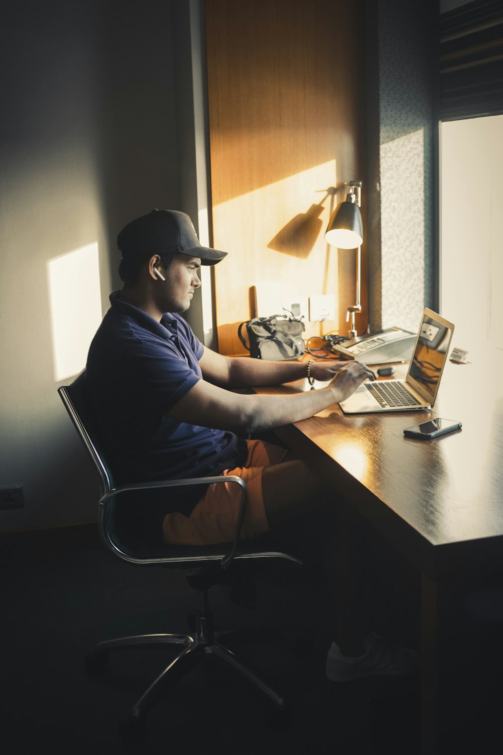 man in blue shirt sitting on chair in front of table