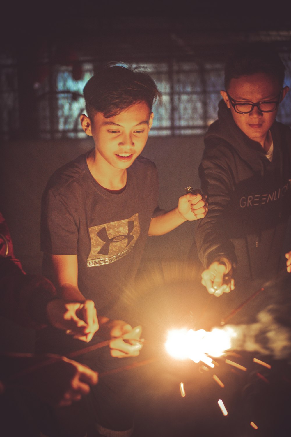 man in black crew neck t-shirt holding lighted sparkler