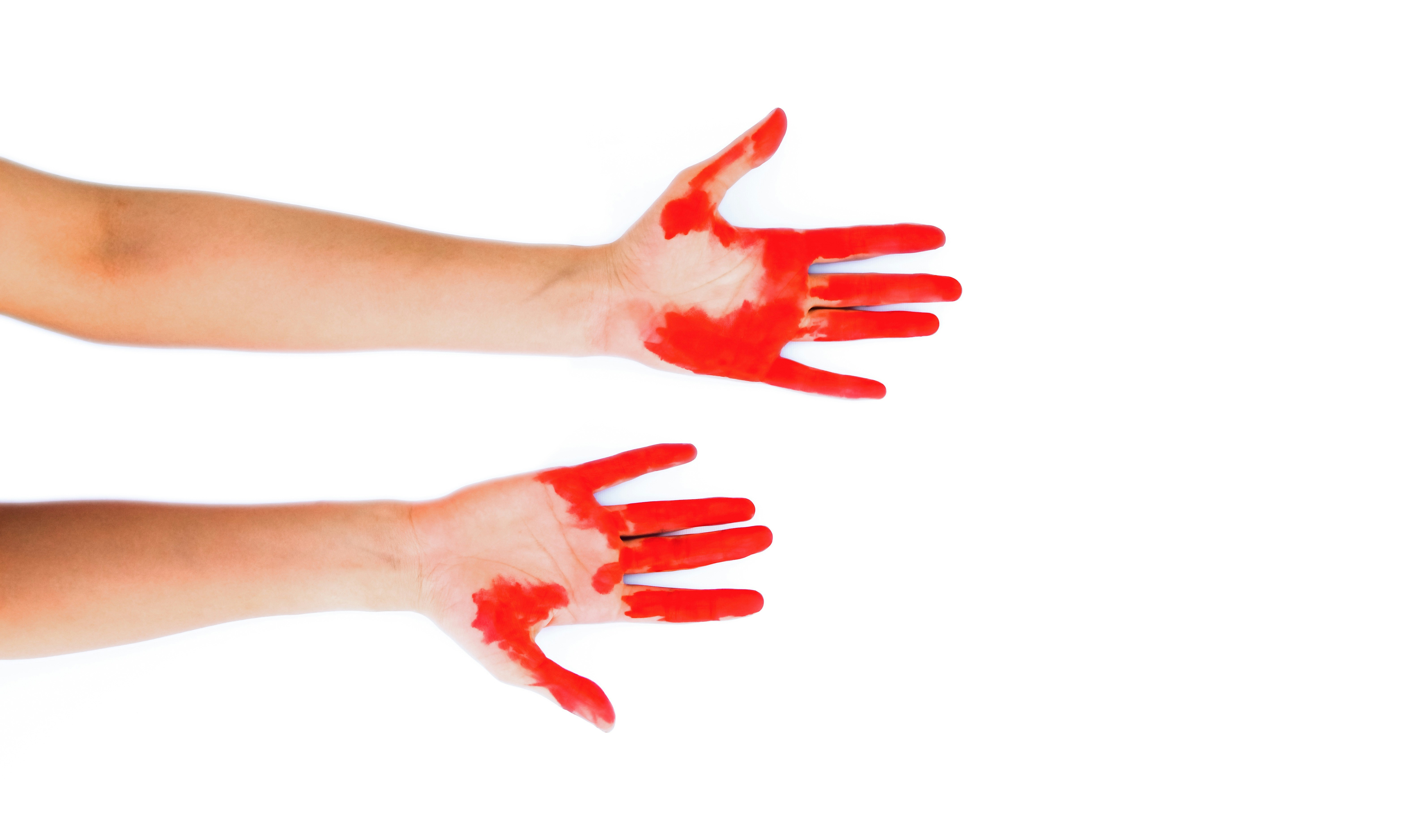 Hands wearing protective gloves spattering paint under bright lighting