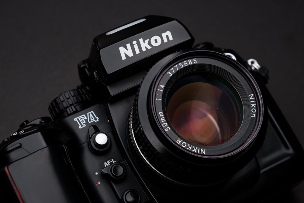 black nikon dslr camera on white surface