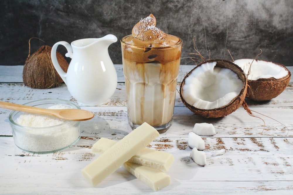 white ceramic pitcher beside clear glass pitcher on brown wooden table