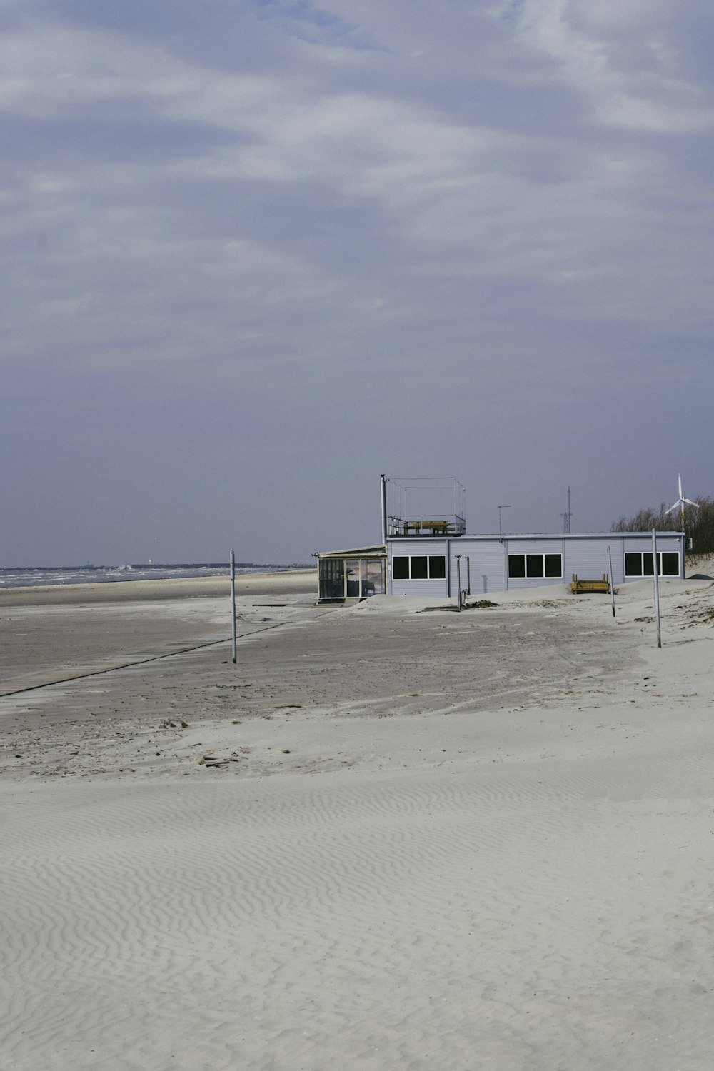 white and green house on white sand beach during daytime