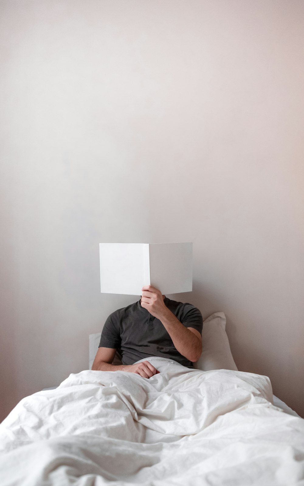 man in black t-shirt lying on bed