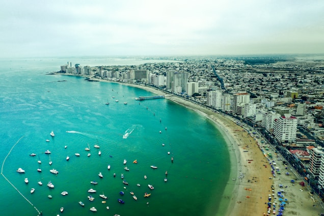 aerial view of boats on sea near city buildings during daytime