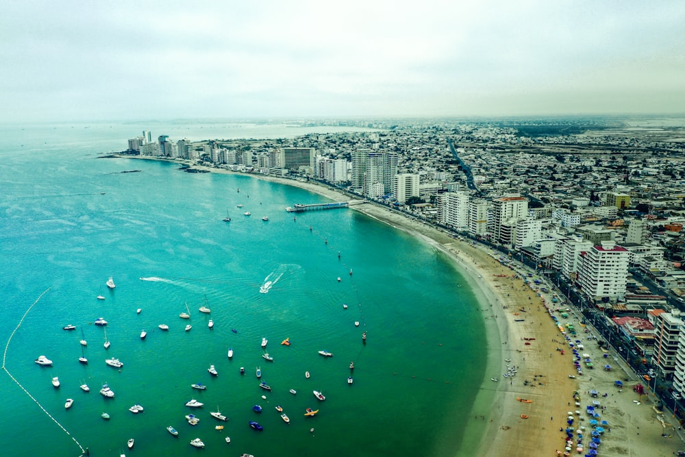 aerial view of boats on sea near city buildings during daytime