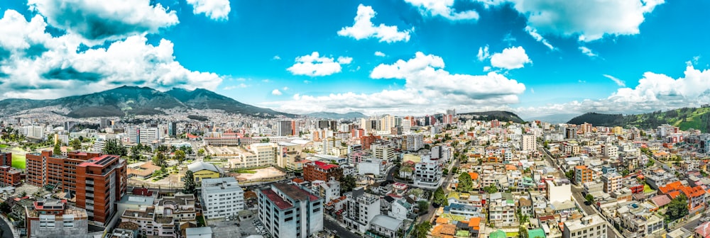 city with high rise buildings under blue and white cloudy sky during daytime