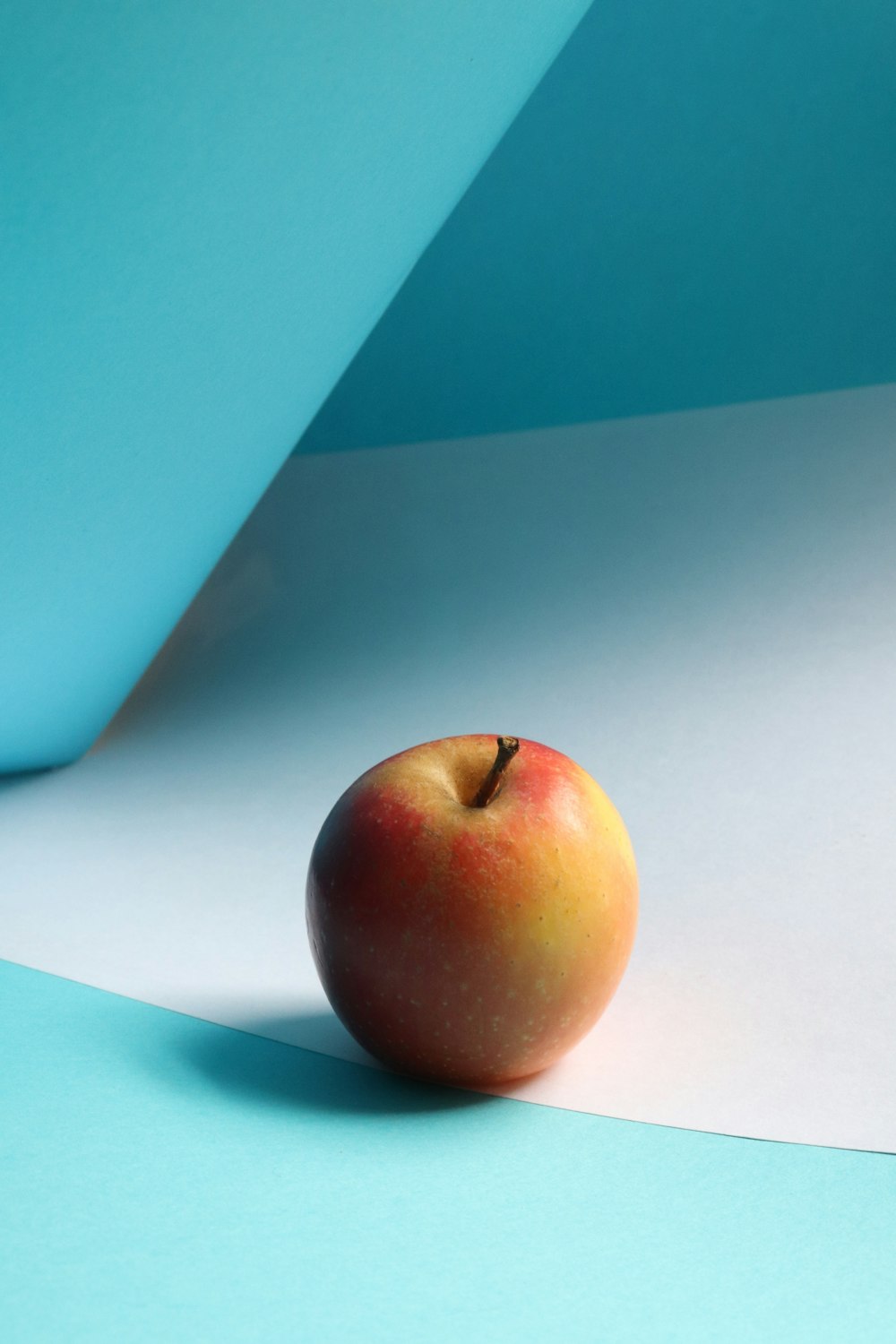 red apple fruit on white table