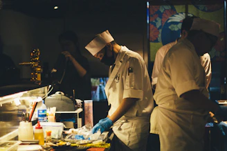 Close-up of hygienic kitchen staff preparing litti chokha with traditional tools.