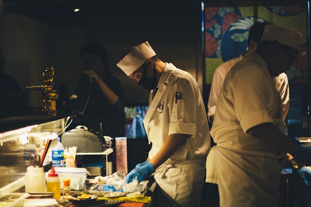 A professional kitchen scene showing disposable gloves and foil in use