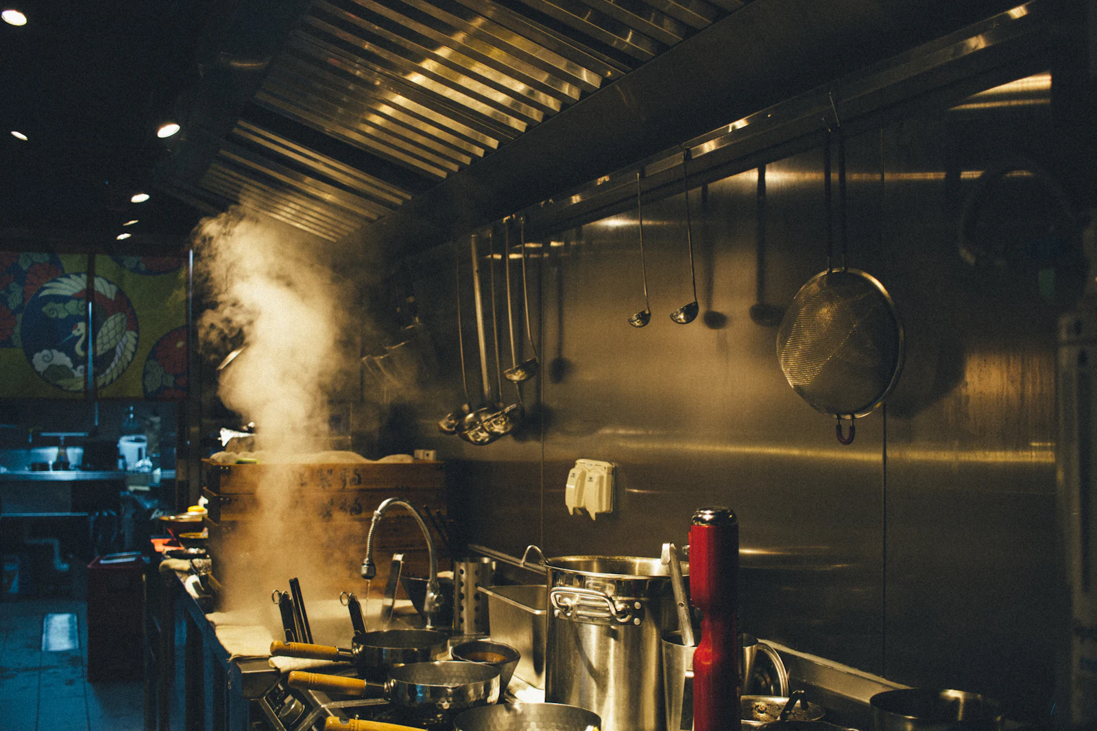 Stainless-steel cooking pots on a heavy-duty commercial gas range