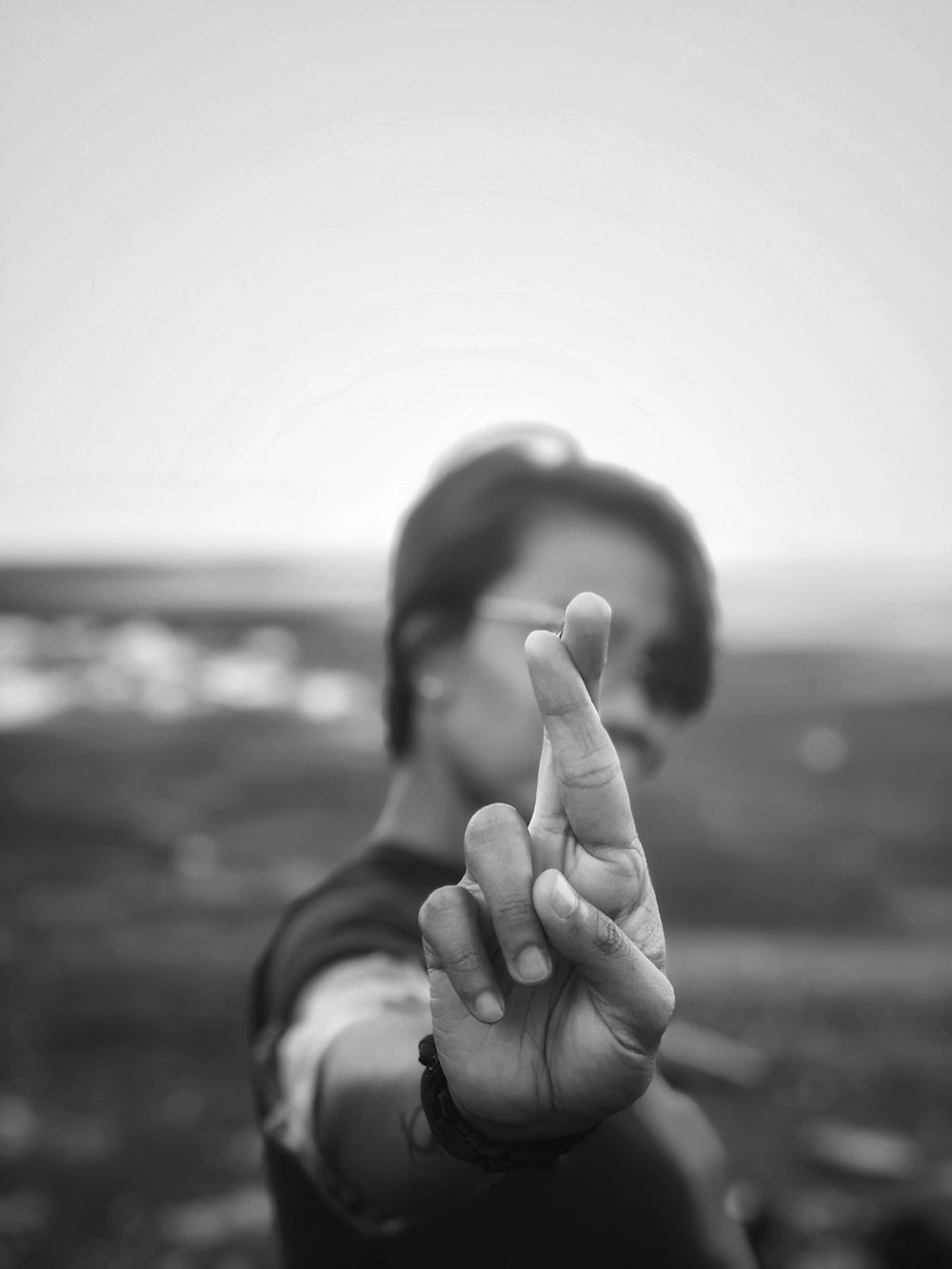 Foto en escala de grises de una mujer haciendo el signo de la paz