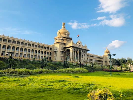 white concrete building under blue sky during daytime in Cubbon Park India