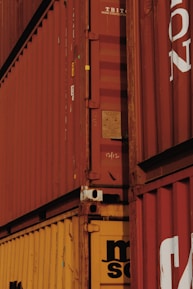 Close-up of hands shaking over a business deal with shipping containers in the background.